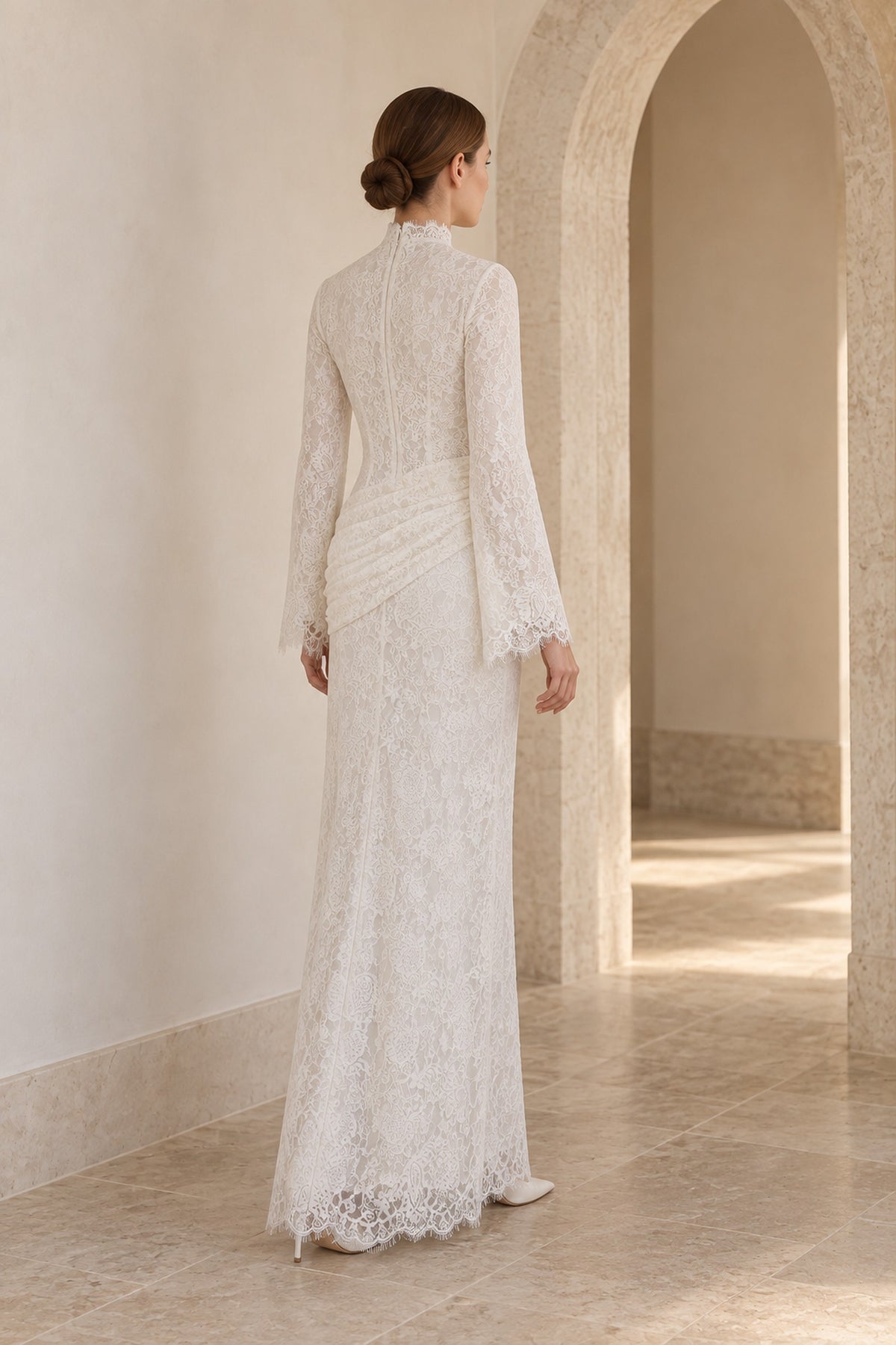 Rear three-quarter view of the Lilia white lace dress in an arched interior, showing the high back and ruched hips