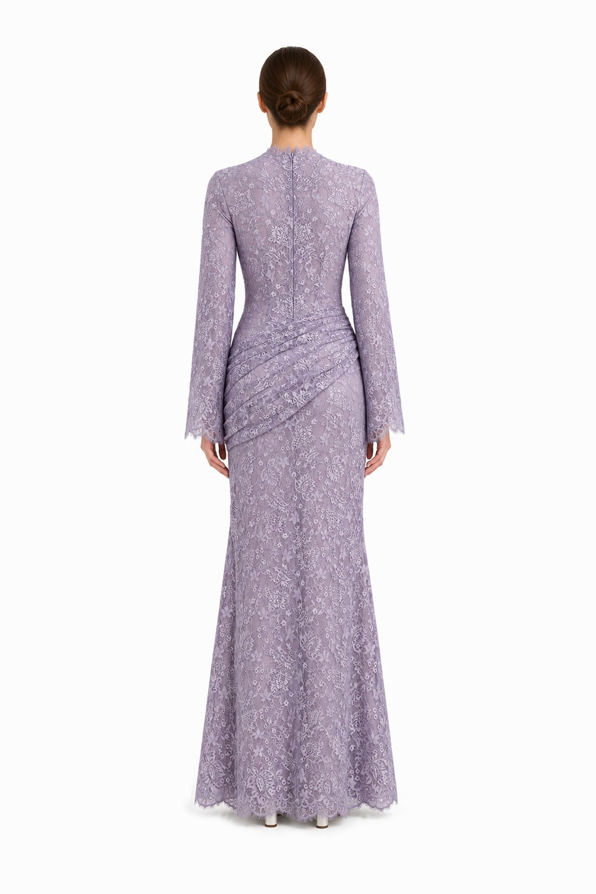 Rear studio view of the Lilia lilac lace maxi dress, showing long sleeves and asymmetric hip draping.