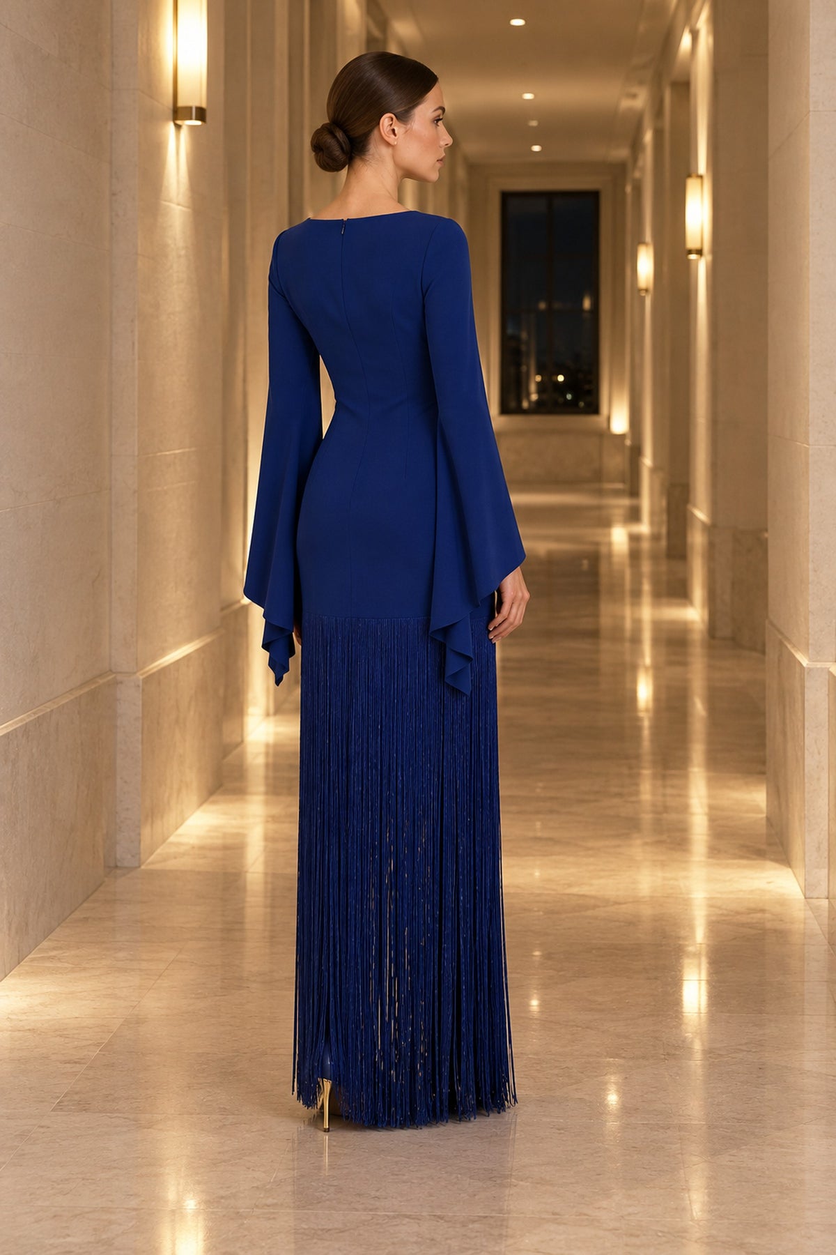 Vesper Night Blue bell-sleeve fringe maxi dress - Rear view in hotel corridor